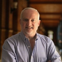 Portrait of the principal of BrilliantAIS, smiling, in a checked shirt